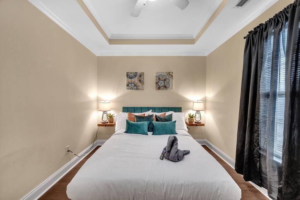 Una habitación de hotel con una cama grande, dos lámparas de pared y dos adornos decorativos en las paredes.