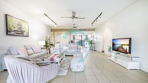 Ein modernes Wohnzimmer mit einer Couch, einem Couchtisch und einem Fernseher.