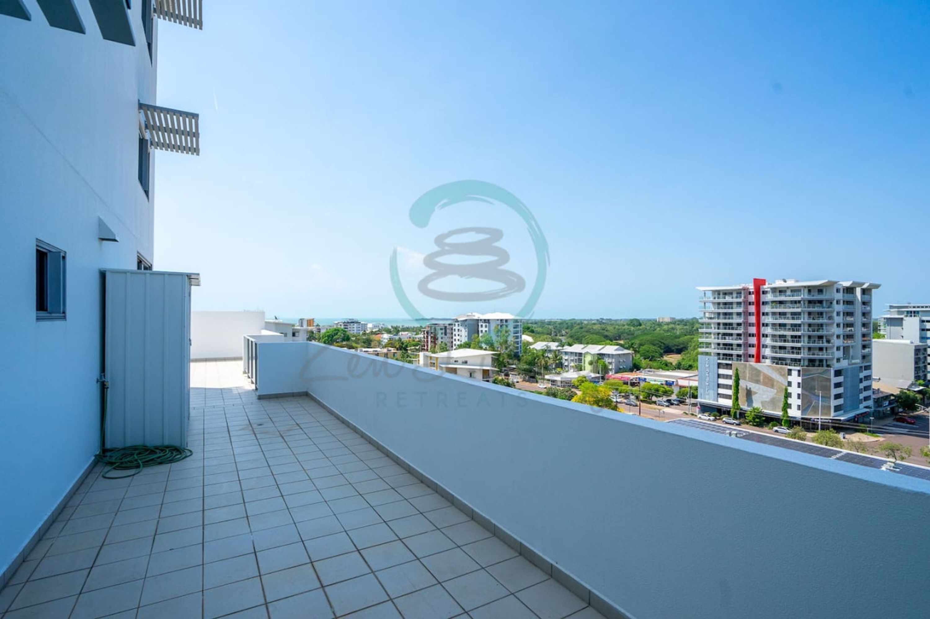 A rooftop terrace with a clear view of the surrounding buildings and a distant landscape.