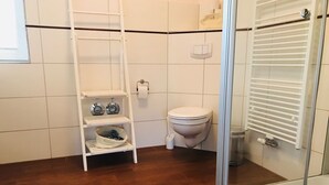 Regadera, secadora de cabello, toallas, papel de baño