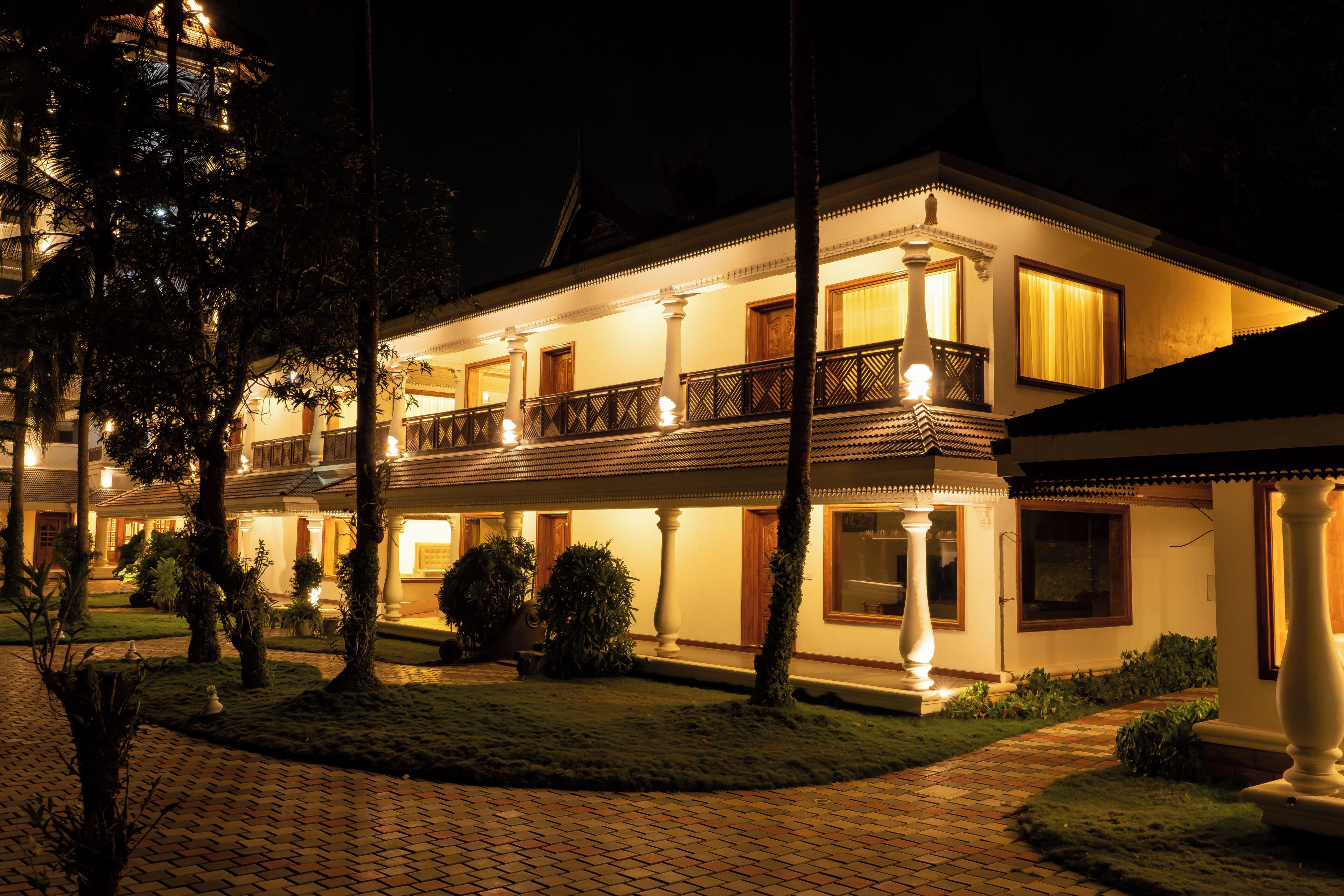 A two-story building with a balcony, columns, and a well-lit entrance.