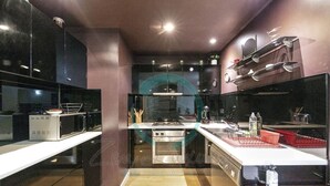 A modern kitchen with stainless steel appliances, a central island, and a glass backsplash. - Urban Haven Boutique 1BR Apt Near Parap Markets (Parap)