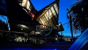 Un bâtiment moderne doté d’une façade en verre et d’un espace piscine.