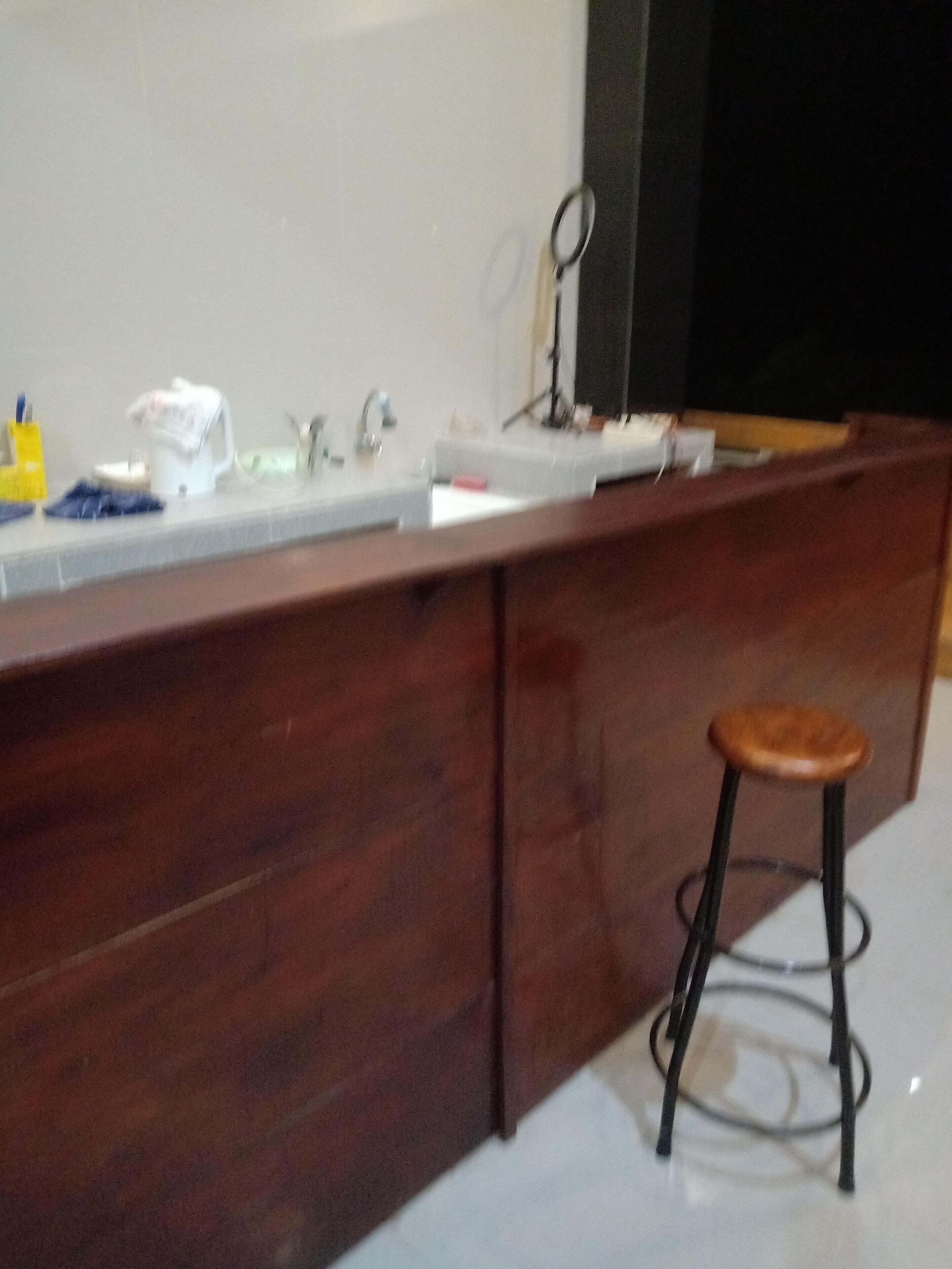A bathroom with a wooden vanity, a sink, and a stool.