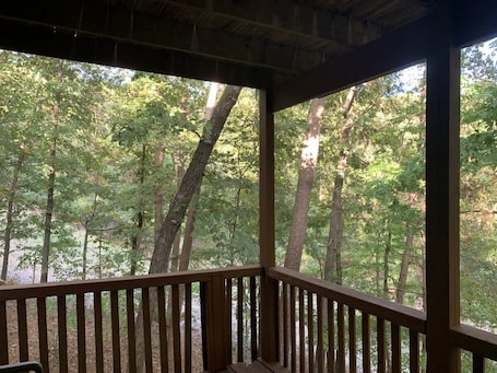 A wooden deck with a view of a forested area.. Serene Townhome Retreat in Hot Springs