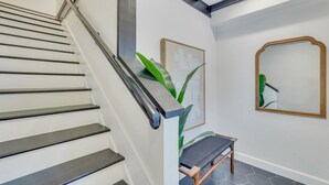Una escalera con barandilla de metal y un banco de madera al final.