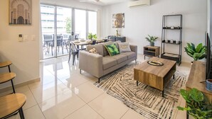 Un salon moderne comprenant un canapé, une table basse et un coin repas avec des chaises et une table.