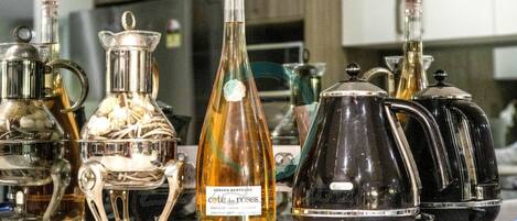 A kitchen with various glassware and bottles, including a bottle labeled "cote des roses".