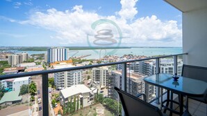 A balcony with a clear view of a coastal cityscape, including buildings and a body of water. - Zen Ocean Pebble 1-br 1-ba Sea View Retreat (Darwin)