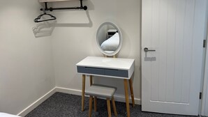 A small, clean room with a white desk, a round mirror, and a door. - Stunning 1 Bedroom Apartment in Bicester Town (Bicester)