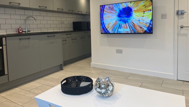 A modern kitchen with grey cabinets, a black microwave, and a white countertop. - Stunning 1 Bedroom Apartment in Bicester Town (Bicester)