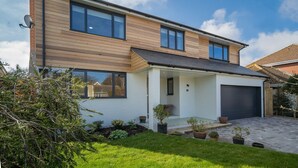 A modern two-story house with a garage, a covered porch, and a well-maintained lawn. - The Beach House - sleeps 8 guests  in 4 bedrooms (Bembridge)