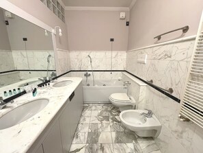 A bathroom with a double sink, a bathtub, a toilet, and a bidet. - Best View Boutique Apartments  (Bergamo)