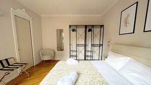 A hotel room with a large bed, a chair, a wardrobe, and a mirror. - Best View Boutique Apartments  (Bergamo)