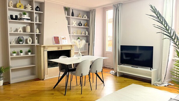 A living room with a fireplace, a TV, and a dining area with chairs. - Best View Boutique Apartments  (Bergamo)