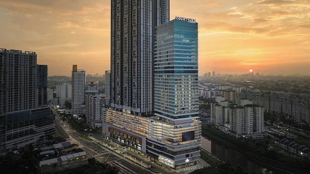 Un edificio de gran altura con un diseño arquitectónico moderno, que presenta un llamativo letrero de 'Courtyard' en la parte superior.