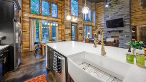 Una cocina amplia con una isla grande, paredes de madera y una pared decorativa de piedra.