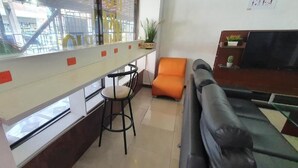 A modern hotel lobby with a bar area, seating, and a large window offering a view of the outside. - HOTEL GRAN IMPERIO (Medellín)