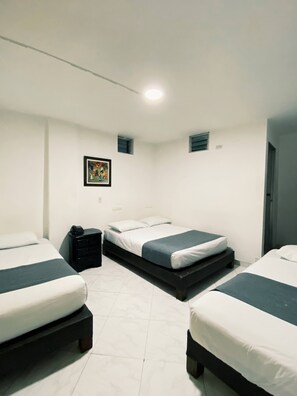 A bedroom with two beds, a bedside table, a small painting, and a window. - HOTEL GRAN IMPERIO (Medellín)