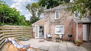 A stone house with a patio, a wooden fence, and a garden. - Lavender Cottage -  a cottage that sleeps 2 guests  in 1 bedroom (Portscatho)