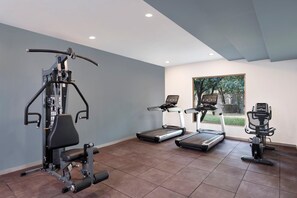 A gym with a treadmill, elliptical, and weight machine. - Voco Jim Corbett (Ramnagar)