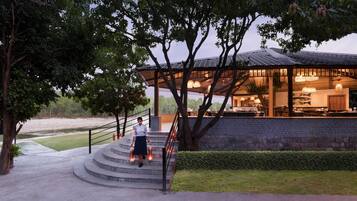 Un restaurante con terraza al aire libre, una escalera que lo lleva a él y vistas del paisaje circundante.