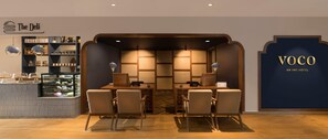 A hotel lobby with a reception desk, seating area, and a wall with the hotel name 'VOCO AN THE HOTEL'. - Voco Jim Corbett (Ramnagar)