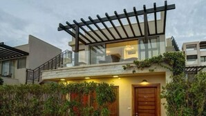 A modern house with a glass balcony, a wooden door, and a pergola. - Rose beach chalet  (Aqaba)