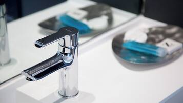 Un bagno moderno con un rubinetto cromato, uno specchio e un lavandino.