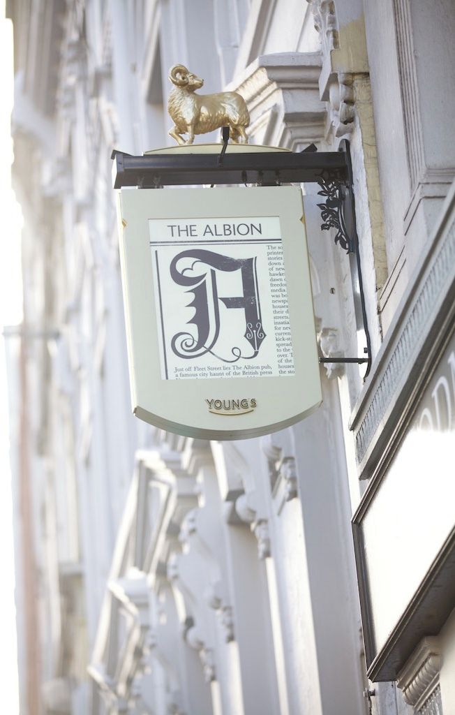 A pub sign with a large 'F' and the name 'The Albion' hanging from a building.