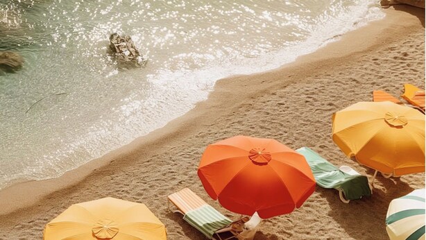 A beach with several umbrellas and lounge chairs.