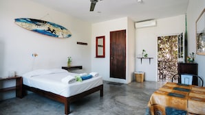 A bedroom with a bed, a ceiling fan, a wooden door, and a view of the outside. - Puerto Dreams H (Puerto Escondido)