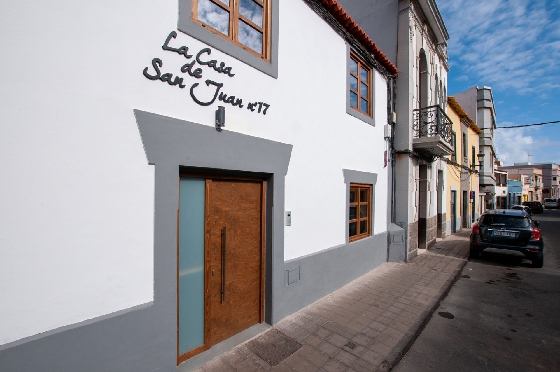 A building with a sign reading "La Casa de San Juan 17" on a white wall.