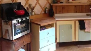 Cuina pràctica amb fogó, forn i armaris de fusta.