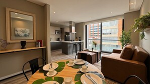 A modern apartment with a dining area, kitchen, and living space.