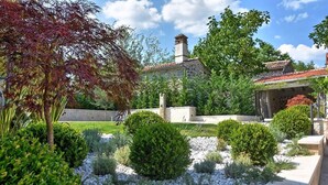 A landscaped garden with a stone building, various shrubs, and a clear sky. - A country 5 stars villa Zita (Jakomici)