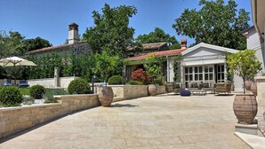 A patio area with stone flooring, outdoor furniture, and large planters. - A country 5 stars villa Zita (Jakomici)