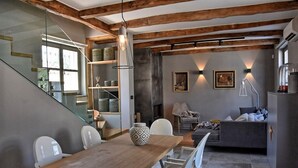 A modern kitchen with a wooden dining table, white chairs, and a built-in oven. - A country 5 stars villa Zita (Jakomici)