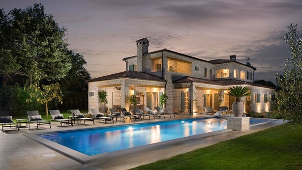 A large, two-story stone house with a swimming pool, outdoor seating, and a well-maintained lawn. - Beautiful Villa Nevia with Private Pool (Ladici)