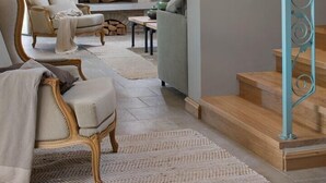 A cozy living room with a stone fireplace, comfortable seating, and a staircase with a decorative railing. - Beautiful Villa Nevia with Private Pool (Ladici)