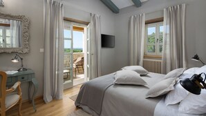 A bedroom with a bed, a desk, a chair, a TV, and a view of the outdoors. - Beautiful Villa Nevia with Private Pool (Ladici)