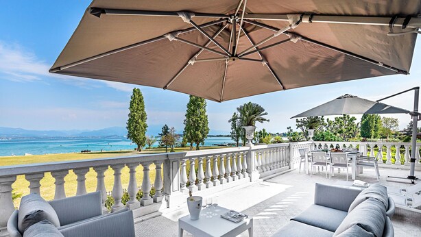 Una terraza con mobiliario exterior, una mesa y vistas al mar.
