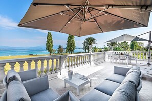 Una terraza con mobiliario exterior, una mesa y vistas al mar.