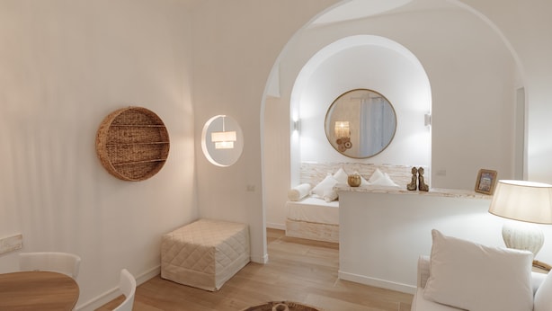 A modern, minimalist bathroom with a round mirror, a wooden wall shelf, and a small seating area. - Vatican home for seven people  (Rome)