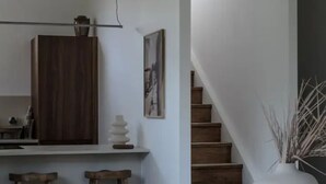 A modern kitchen with wooden cabinets, a dining area with a table and chairs, and a staircase leading to another level. - Beautiful villa in Pyla, 2 min walk from beach (La Teste-de-Buch)