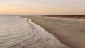 A beach with gentle waves, a sandy shore, and a distant dune. - Beautiful villa in Pyla, 2 min walk from beach (La Teste-de-Buch)