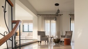 Un salón espacioso con techo alto, una escalera y vista a un balcón.