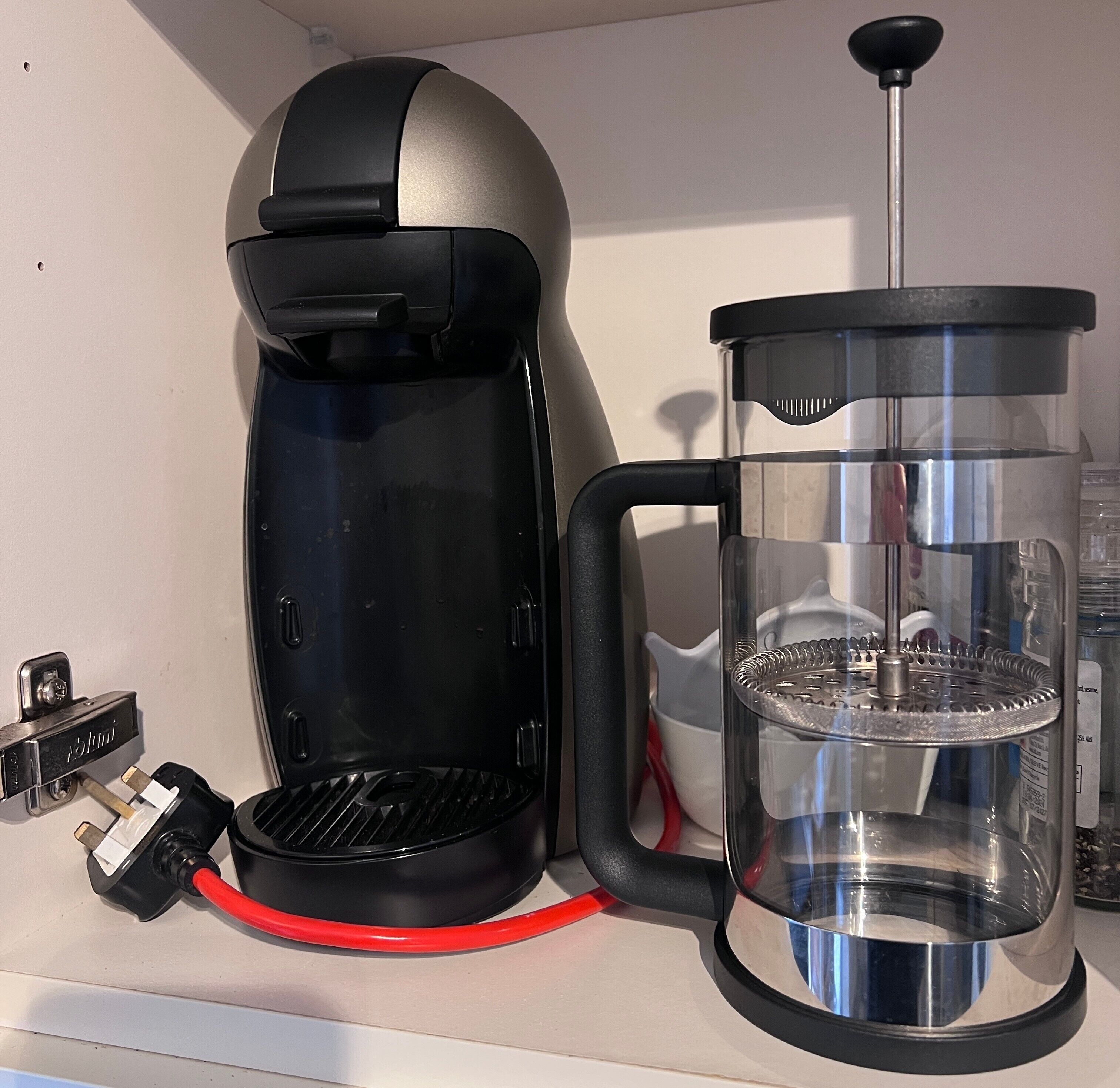 Een koffiezetapparaat en een cafetière op een aanrecht.