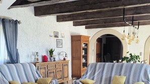 A cozy living room with striped sofas, a wooden coffee table, and a rustic ceiling. - House at the foot of the Luberon with swimming pool 5 minutes from the village of Lourmarin, (Puyvert)