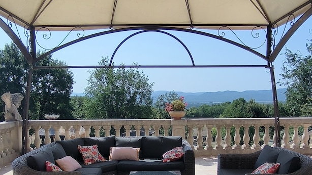 An outdoor seating area with wicker furniture, a central table, and a decorative ceiling. - House at the foot of the Luberon with swimming pool 5 minutes from the village of Lourmarin, (Puyvert)